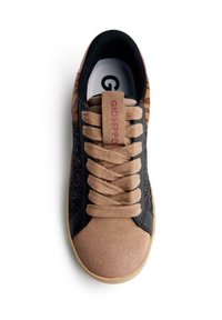 Zapatilla con parte superior de cuero negro, puntera de ante marrón claro y patrones texturizados. Cuenta con cordones color tostado y una etiqueta de logo marrón en la lengüeta.