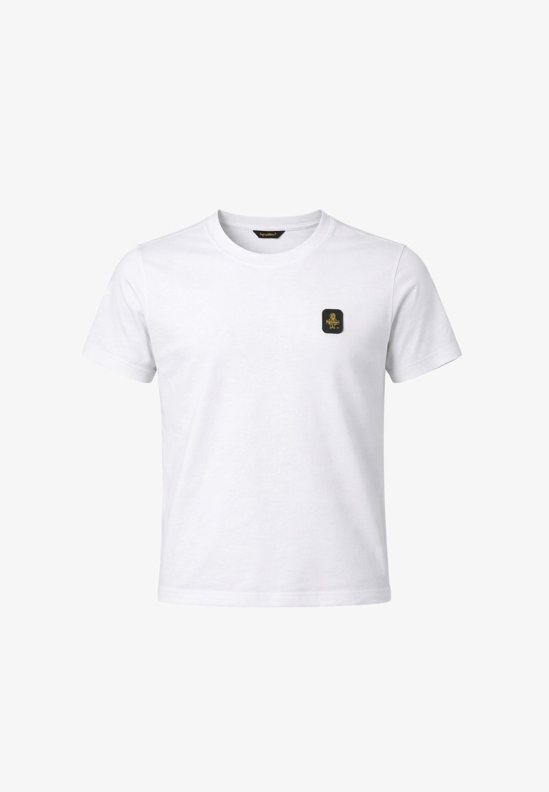 T-shirt bianca a maniche corte con scollo tondo e una piccola toppa nera e oro sul petto a sinistra.