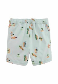 Shorts de bain pour garçons en tissu vert clair avec un imprimé d'ours sur une planche de surf. Dotés d'une taille élastique et d'une texture lisse, adaptés aux activités aquatiques.