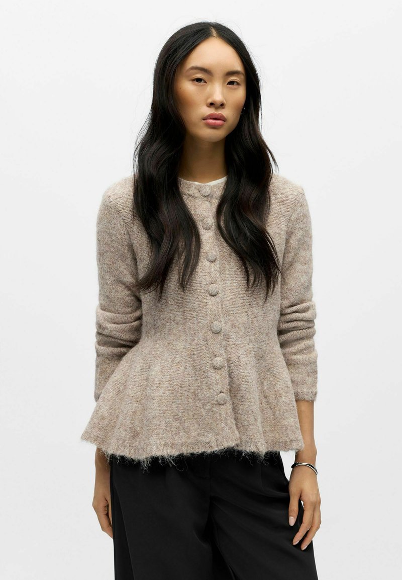 Lysebrun uldcardigan med peplumdesign, rundet halsudskæring og seks store knapper, med lange ærmer og blød tekstur.