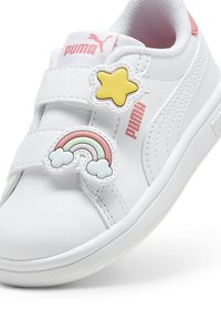 Vita syntetiska sneakers med kardborreband, dekorerade med en gul stjärna och ett regnbågsdesign. Puma-logotyp i rosa.