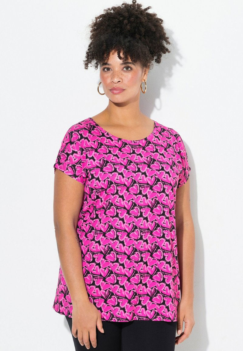Top de manga corta hecho de tela rosa con un patrón de mariposas negras. Presenta un escote redondo y un diseño de corte relajado.