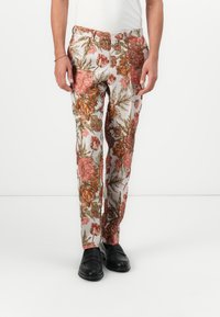 Blomstrete bukser med et lysende, flerfarget mønster av rosa og oransje blomster på en kremhvit bakgrunn, med avslappet passform og strukturert stoff.