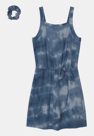 Niebieska sukienka tie-dye z cienkimi ramiączkami, dekoltem w łódkę i paskiem w talii. Do zestawu dołączona jest dopasowana gumka do włosów. Gładka faktura materiału.