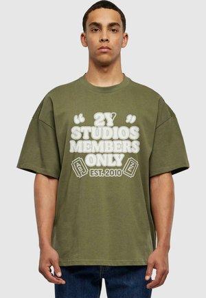 Olivegrünes, oversized Baumwoll-T-Shirt mit dem weißen Grafiktext "2Y STUDIOS MEMBERS ONLY EST. 2010" auf der Vorderseite. Kurze Ärmel, runder Ausschnitt.