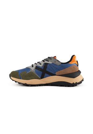 Chaussure de sport basse en bleu, gris, vert et marron avec des lacets noirs, une semelle beige et une languette orange au talon sur fond blanc.