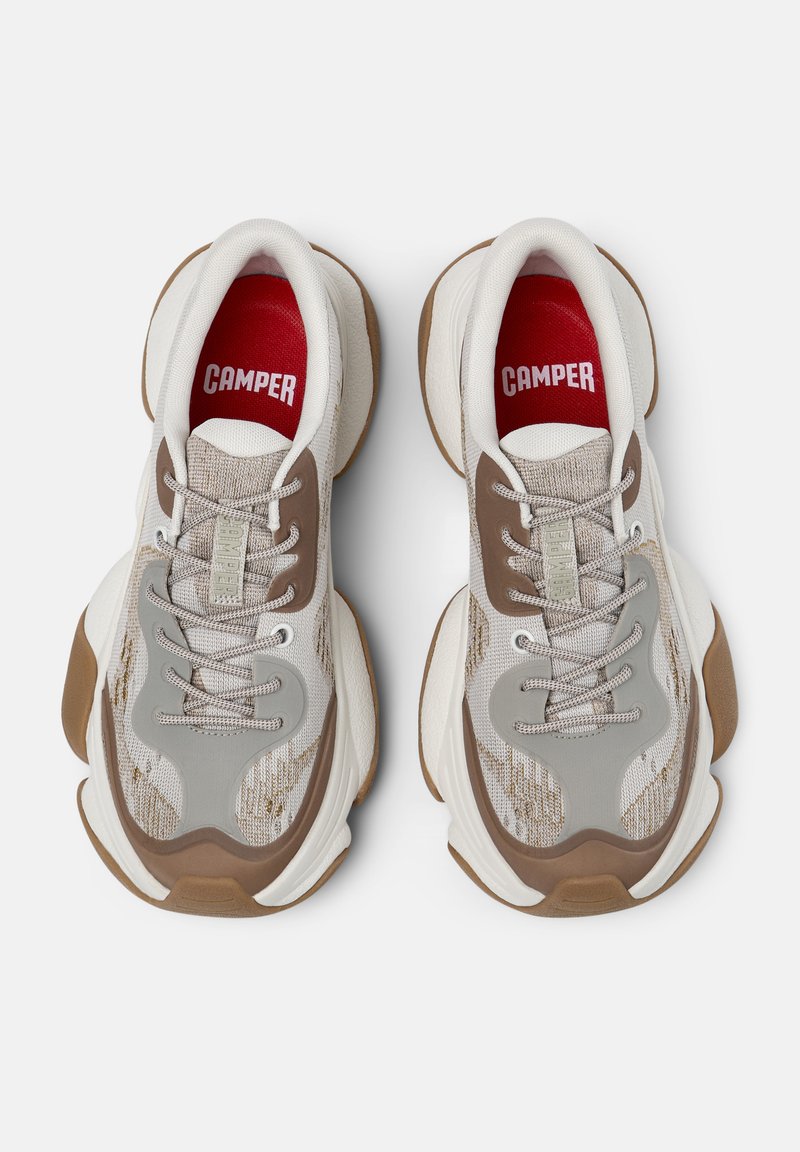 Lettrætte sneakers i beige og grå mesh med brune accenter, der har en tekstureret overdel, snørebånd og en gummisål. Rødt logo indeni.
