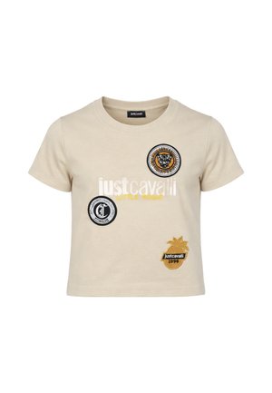 T-shirt beige per bambino con maniche corte e scollo rotondo, con logo Just Cavalli, toppa a forma di tigre, emblema circolare e toppa a forma di ananas.