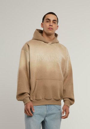 Felpa beige con effetto sfumato, dotata di tasca frontale e la parola "KANI" ricamata in bianco. Tessuto morbido e vestibilità comoda.
