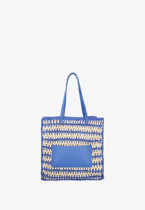 Blue and cream woven tote bag with leather handles and a front pocket. Features a rectangular shape and textured fabric.