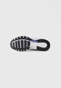 Sole di scarpa da corsa Nike con battistrada in gomma nera e bianca e ammortizzazione ad aria visibile su sfondo bianco.