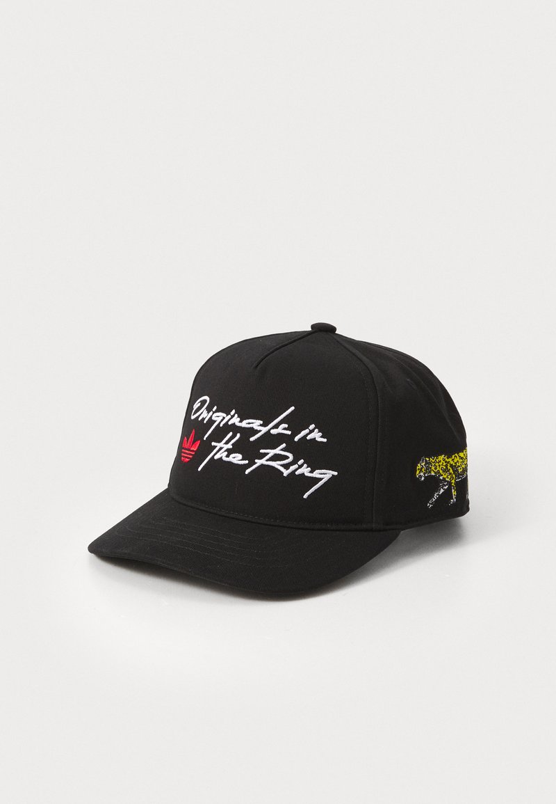 Boné preto de algodão com texto bordado "Original in The Ring" em branco, logótipo vermelho da Adidas e um gráfico de leopardo amarelo de lado.