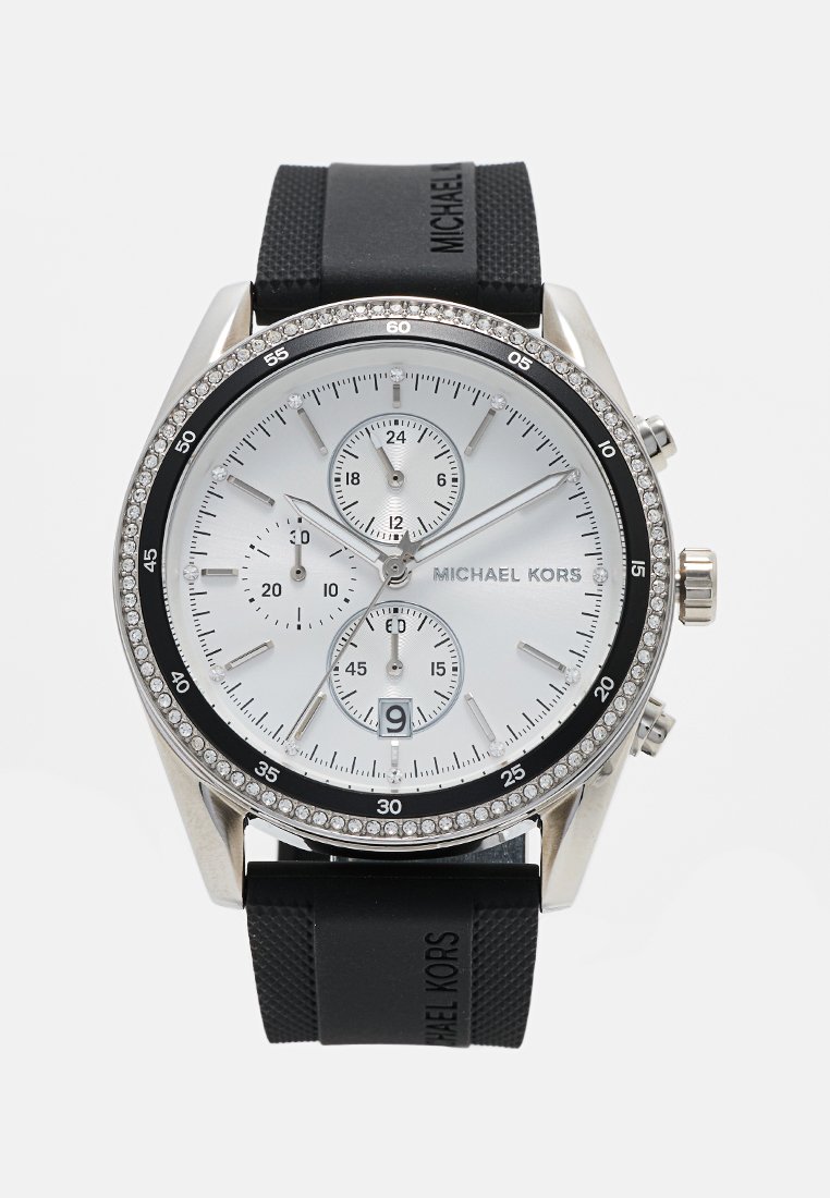 Silberne und schwarze Michael Kors Chronograph-Uhr mit einem strukturierten schwarzen Gummiband, weißem Zifferblatt, drei kleinen Zifferblättern und Kristallakzenten auf der Lünette.