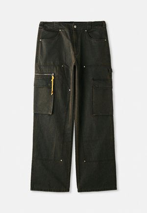 Fekete cargo nadrág laza szabással, számos zsebbel, sárga cipzárhúzókkal és texturált anyaggal, amely elhalványult hatású.