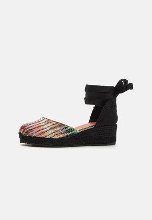 Wedge espadrille with a multicolored sequined toe cap and black ankle ties. Features a woven jute midsole and textured black outsole.