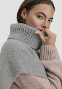 Lichtgrijze en roze gebreide trui met een hoge ribbelsluiting en een zachte textuur, met een gespleten ontwerp bij de schouders en mouwen.