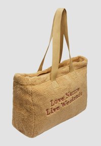 Torebka tote z jasnobrązowego materiału pluszowego z jasnobeżowymi uchwytami. Posiada haftowany napis: "Kochaj Naturę, Żyj Weekendami." Prostokątny kształt, miękka tekstura.