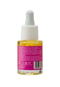 Olio giallo in una bottiglia contagocce di vetro trasparente con un tappo bianco e azzurro chiaro. L'etichetta presenta uno sfondo rosa con testo e icone bianche.