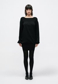 Μαύρο φόρεμα με τετράγωνη λαιμόκοψη, φαρδιά κορυφή και εφαρμοστή φούστα. Διαθέτει μακριά, σούρες μανίκια και απαλή υφή. Φοριέται με μαύρες καλσόν.