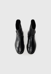 Black leather ankle boots with a smooth finish, side zipper closure, and a circular buckle accent, featuring a rounded toe and low heel.