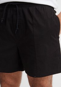 Mustad lühikesed püksid, valmistatud kergest kangast, millel on elastne vöökoht tõmblukuga. Taskud asuvad külgedel.