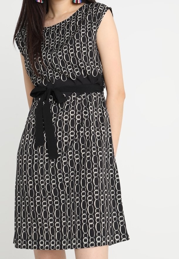 Černé šaty s řetězovým vzorem v bílé barvě, s krátkými rukávy, páskem v pase a volným střihem. Hladká tkanina s jemným splýváním.