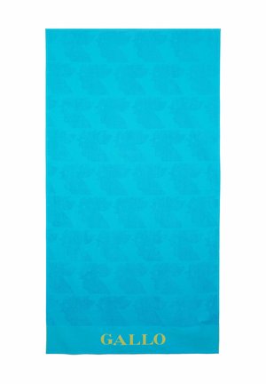 Asciugamano da spiaggia turchese con un motivo ripetuto di silhouette, con un logo dorato "GALLO" sul bordo inferiore. Tessuto morbido e testurizzato.