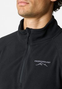 Schwarzer Fleece-Pullover mit hohem Kragen, mit halbem Reißverschluss vorne, und weißem, gesticktem „SWEDEMOUNT“-Logo über einer Berggrafik. Glatte Textur.