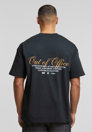 Svart bomull t-skjorte med hvit og gull tekst på ryggen, inkludert "Out of Office" og arrangementdetaljer i forskjellige skrifttyper.