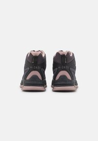 Schwarze und rosafarbene Sport Schuhe mit einem strukturierten Mesh-Obermaterial, gepolstertem Kragen, robuster Fersenunterstützung und einer gesprenkelten Gummisohle.