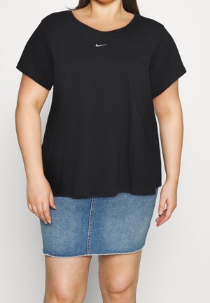 Sort bomulds-T-shirt med korte ærmer og en rund halsudskæring, med et lille hvidt Nike-logo på brystet. Kombineret med et blåt denimskørt.