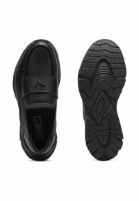 Černé kožené boty s polstrovaným límcem, vybavené suchým zipem a texturovanou gumovou podrážkou s vlnkovým vzorem. Na pásku je logo Puma.