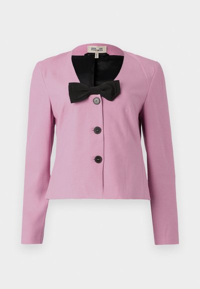Pink cropped jacket with long sleeves, black bow detail at collar, and three black buttons. Smooth fabric with a tailored fit.
