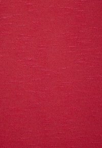 Roter Strickstoff mit glatter Textur, der ein einheitliches Muster und leichte Farbvariationen aufweist. Geeignet für verschiedene Bekleidungsanwendungen.