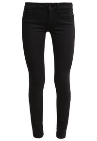 Jeans ajustados negros de denim, con una textura suave, diseño minimalista, cinco bolsillos y un cierre de botón metálico con cremallera.