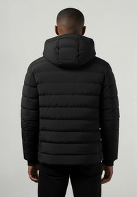 Juodasis pūkų paltas su kapišonu. Turi horizontalų siuvinėtą dizainą ir elastingas rankoves. Medžiaga atrodo blizganti ir lengva.