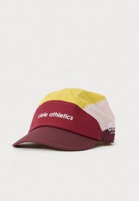 Rdeča, rumena in roza kapa iz lahkega materiala. Ima trd rob in mrežaste panele. Na sprednji strani je napis "ciele athletics."