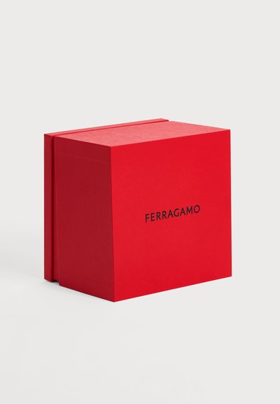 Boîte carrée rouge de marque Ferragamo avec un couvercle séparé, placée sur un fond clair à un angle montrant l’avant et le côté.