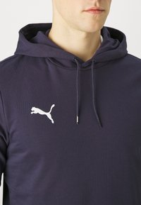 Navyblaue Kapuzenjacke aus Baumwollmischung mit einer vorderen Kängurutasche, verstellbarem Kordelzug und weißem, gesticktem Logo auf der Brust.