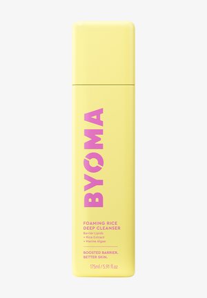 Gele rechthoekige fles met een vlakke bovenkant. Roze tekst met de tekst "BYOMA FOAMING RICE DEEP CLEANSER." Inhoud 175 ml. Eenvoudig, modern ontwerp.