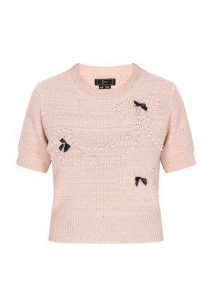 Pulover scurt cu mânecă scurtă, de culoare roz deschis, cu textură tricotată, având accente din panglică neagră și embellismente cu perle într-un model decorativ.