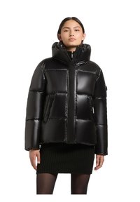 Melnas pārsēdamo jakas ar spīdīgu apdari, par lielu kapuci, rāvējslēdzēja aizdari un lieliem quiltētajiem sektoriem. Nēsāts virs ribota svārka.