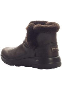 Braune Leder Stiefelette mit Kunstpelzkragen, abgerundeter Spitze und strukturiertem Gummisohle. Mit Skechers-Logo an der Ferse.