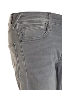 Šedé denímové džíny s klasickým pěti kapsovým designem, viditelným šitím, poutky na opasek a malou značkovou nášivkou na zadním pásu.