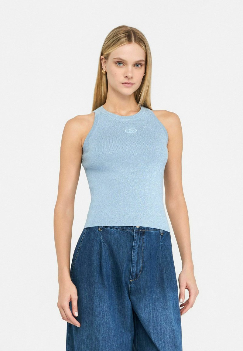 Hele helesinine, soonikuga ribidega tank top, millel on ümar kaelus ja peen sära, ning mis sisaldab väikest logo rinnal, koos laienevate siniste teksadega.