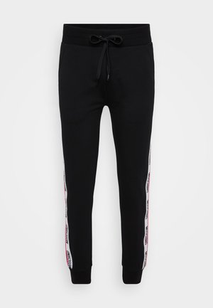 Zwarte joggingbroek met een elastische tailleband en koord, voorzien van rode en witte zijkanten met tekst. Gemaakt van een zachte katoenmix.
