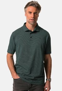 Kortärmad polo i mörkgrön med ett subtilt randm önster, plack med tre knappar och en mjuk textur. Designad för avslappnad användning.