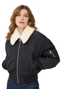 Czarna kurtka bomberka z białym kołnierzem z sztucznego futra, z przodu zapinana na zamek, z bocznymi kieszeniami i kieszenią na rękawie zapinaną na zamek.