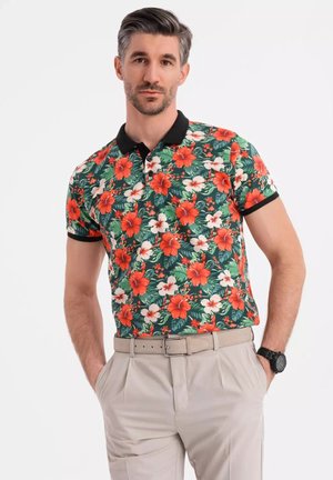 Kortærmet polo skjorte med en sort krave; har et livligt blomstermønster af røde og hvide hibiscus på en grøn baggrund.