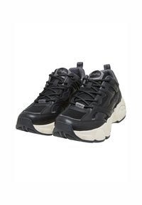 Svarte sneakers med overdel i mesh og lær, med fremtredende snøring, polstret krage og en kraftig hvit såle med teksturert detalj.